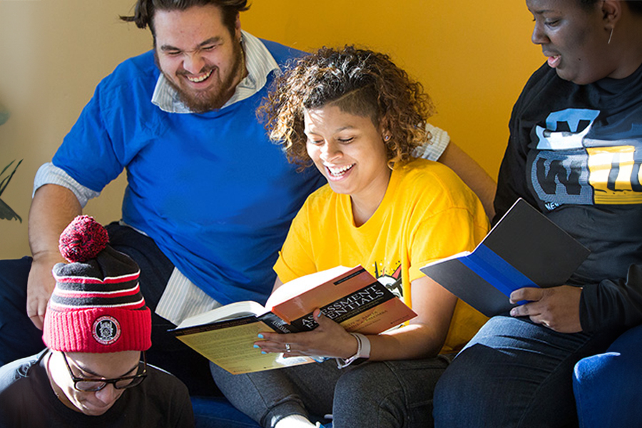 Group of students reading a textbook.