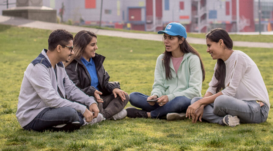 Students sitting on the grass at the Vancouver campus.