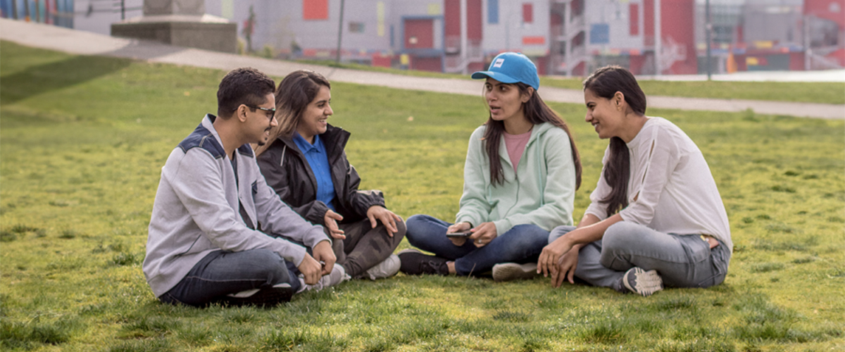 Students sitting on the grass at the Vancouver campus.