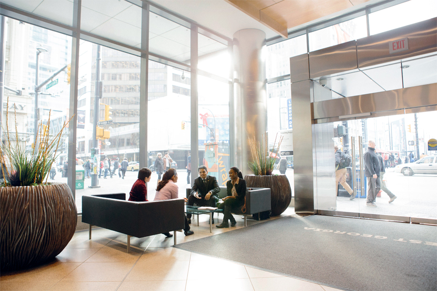 A group of students talk inside the lobby area of New York Tech's Vancouver Campus.