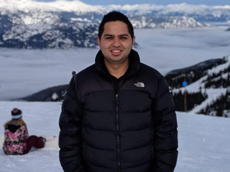 New York Tech Vancouver alumnus Daniel Bocanegra stands on a snow-covered hill.